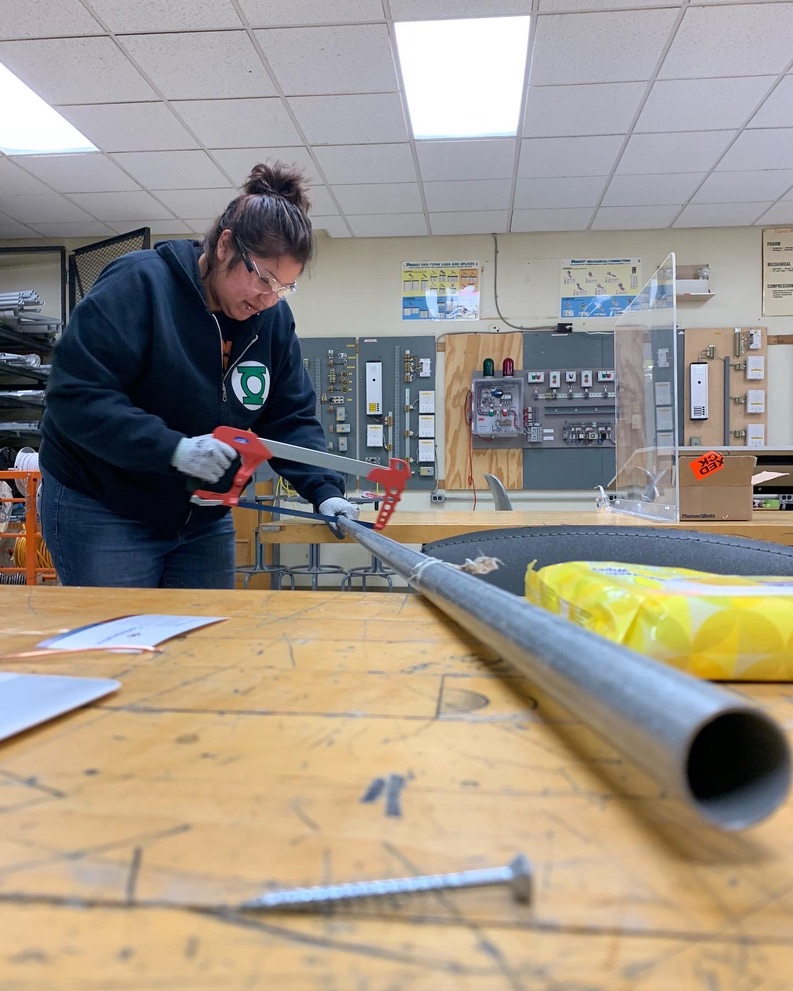 Try-a-Trade student safely cutting electrical conduit in the lab