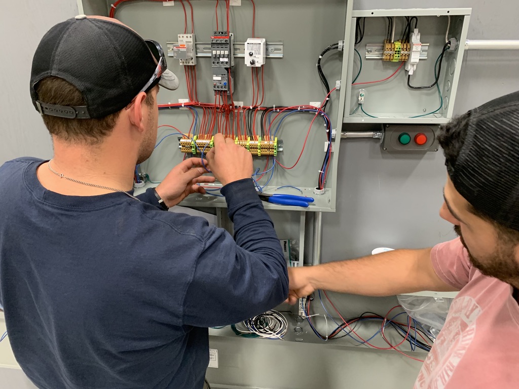 Students wiring a motor-controls training panel