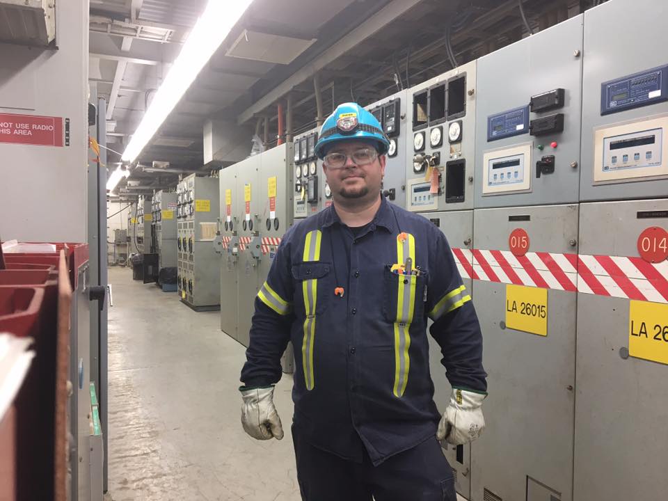 Shawn standing in a motor control centre room as a maintenance electrician